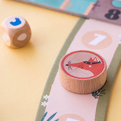 a playing counter and dice sitting on the board of Londji's Cluck Cluck The Fox Game