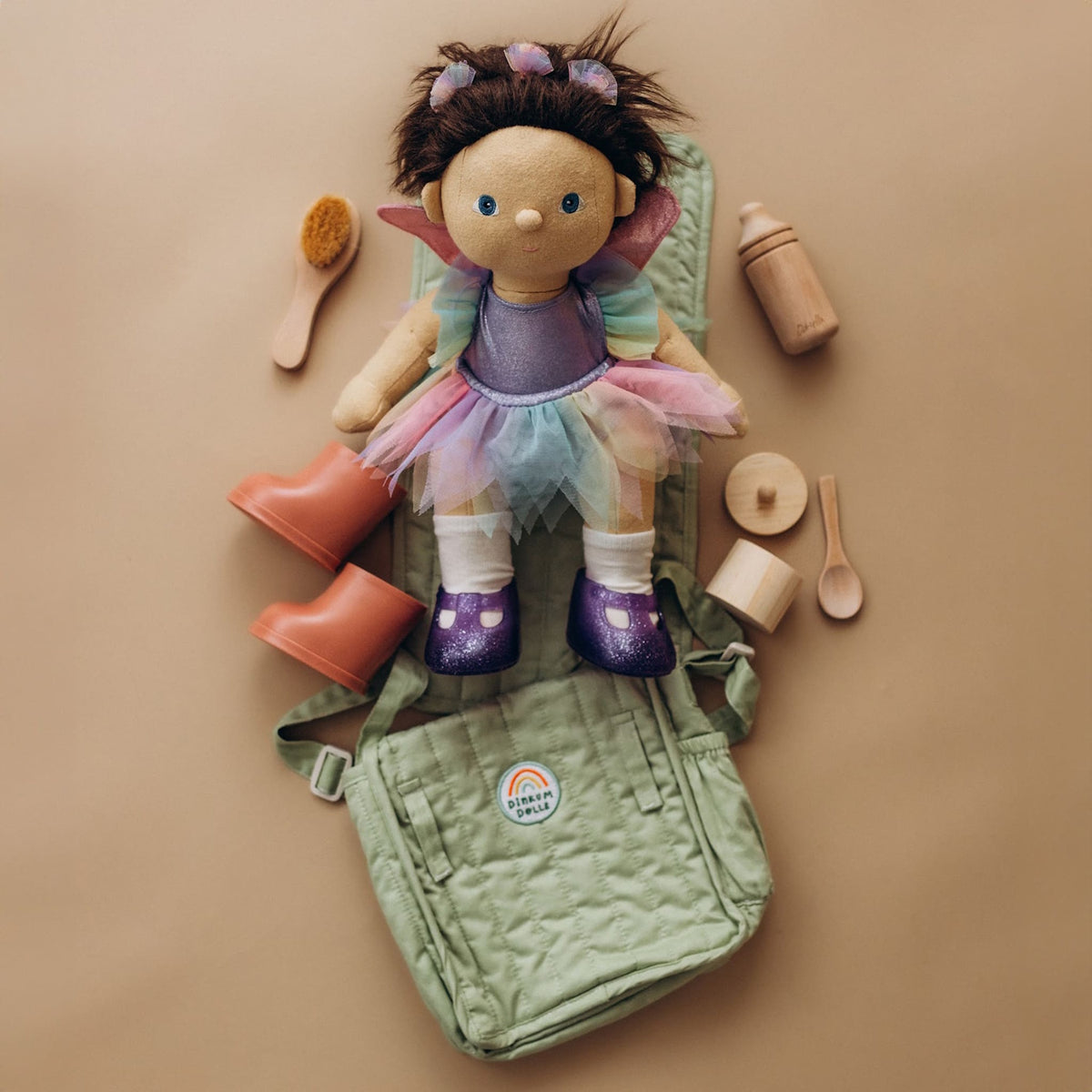 Fairy Dinkum Doll on a sage green convertible changing bag mat with wooden doll accessories.