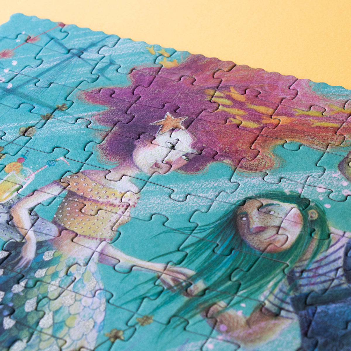A close-up of a mermaid illustration on the puzzle, showing glitter details in her flowing pink hair.