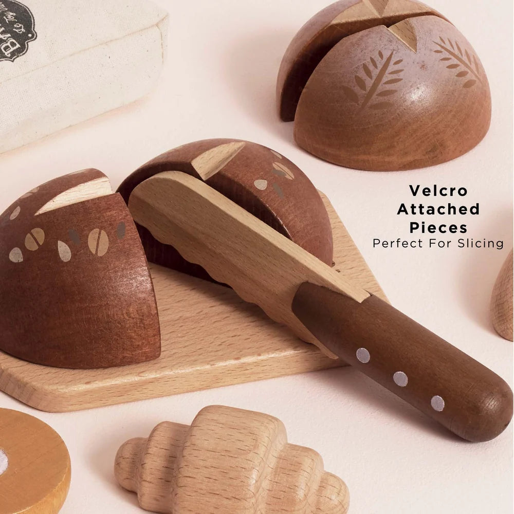 Wooden toy bread on a cutting board being sliced with a toy knife.