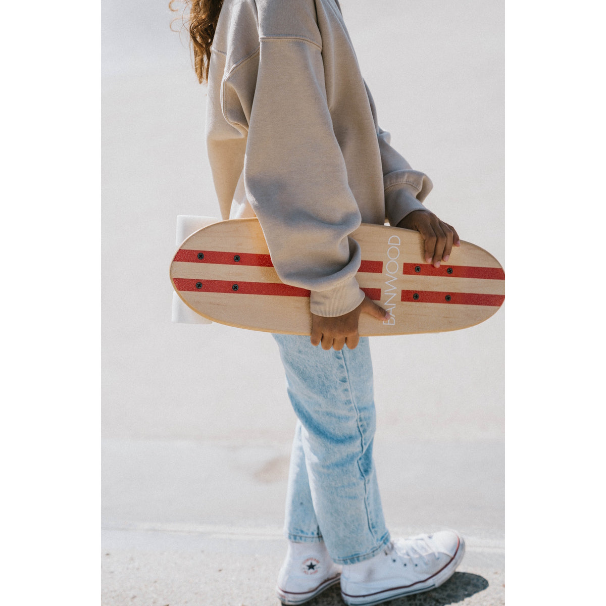 A retro-style cruiser skateboard with a bold red deck, soft wheels, and a sturdy maple wood construction, designed for smooth rides and young skaters.