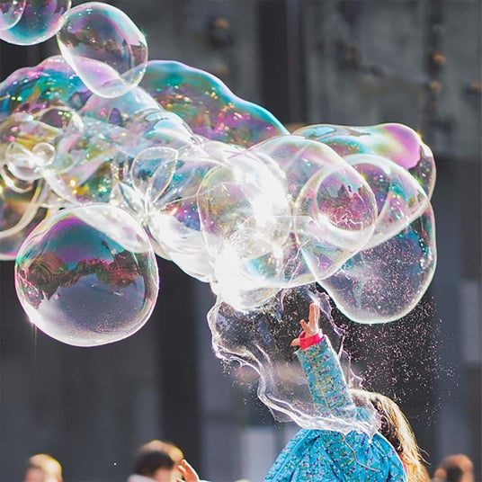 Huge bubbles with a child's arm popping them
