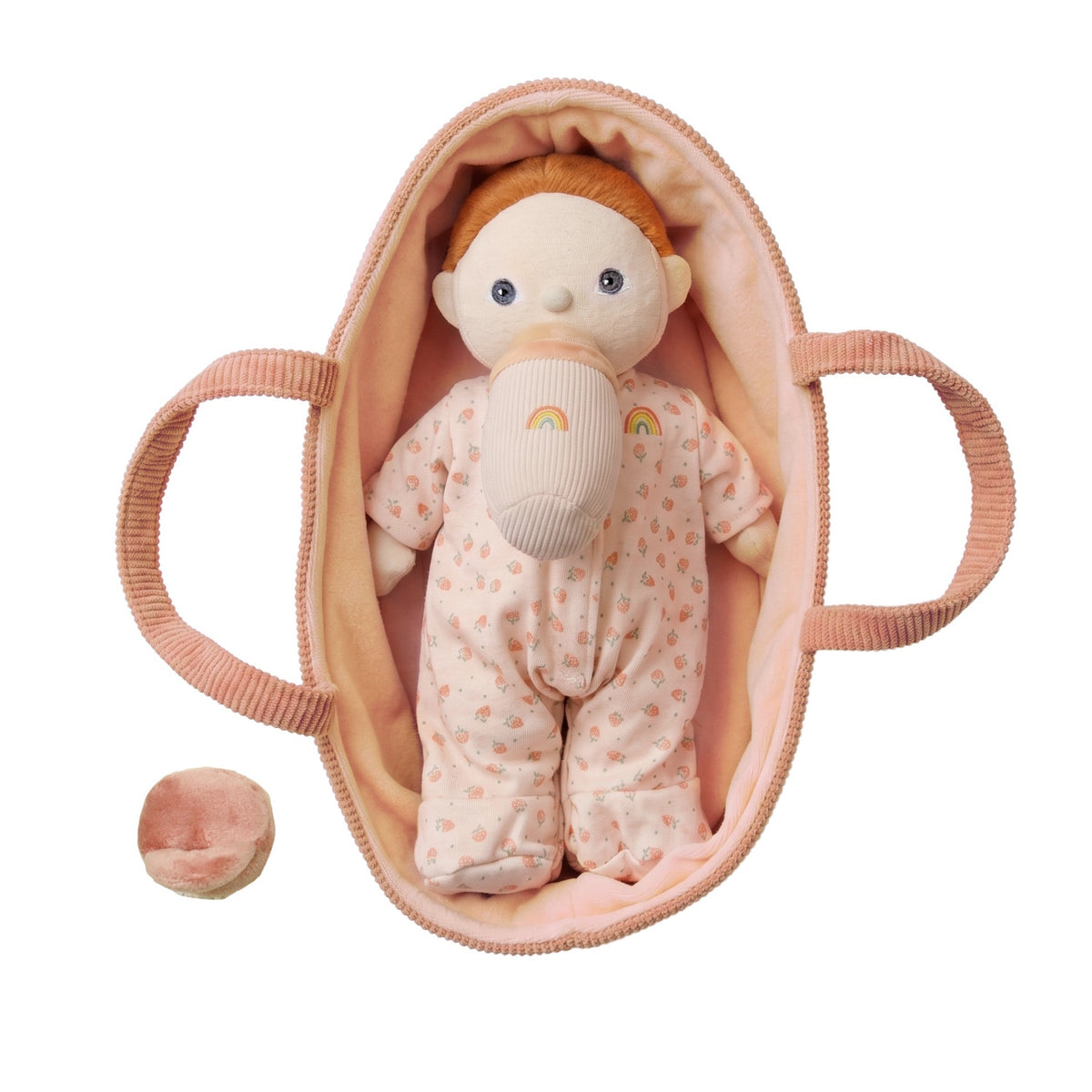 Olli Ella Dinky Dinkum doll with a pacifier lying in a pink corduroy doll bassinet, white background.