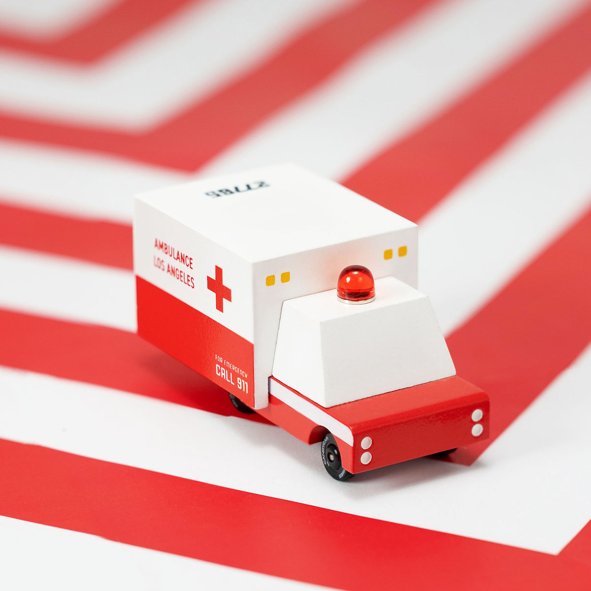 Minimalist wooden toy ambulance by Candylab Toys featuring a white and red Los Angeles design with a red emergency siren.