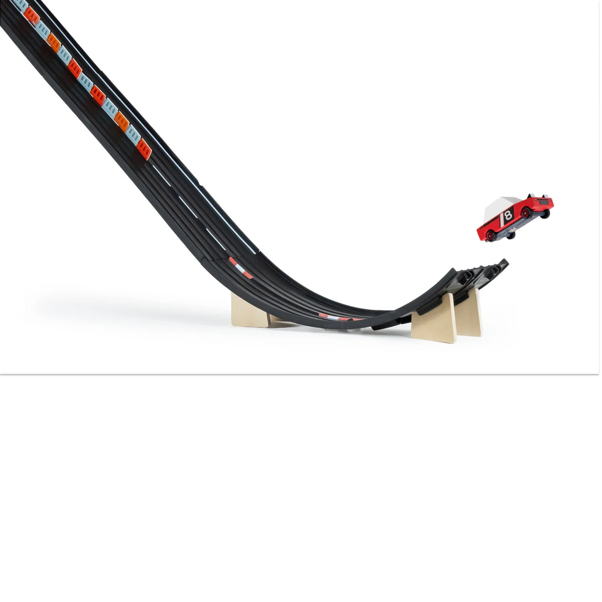 Candylab Roadworks Super Speed playset featuring a red toy car jumping off a black wooden ramp against a white background.
