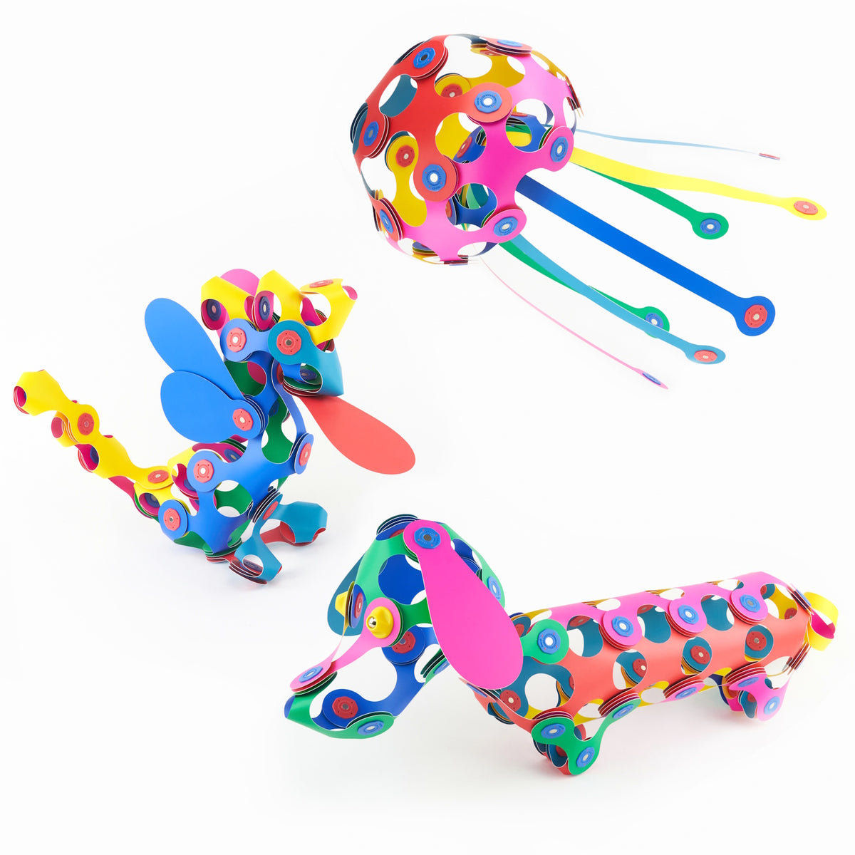 Three colorful 3D figures built from magnetic toy pieces: a jellyfish, a dragon, and a dachshund dog.