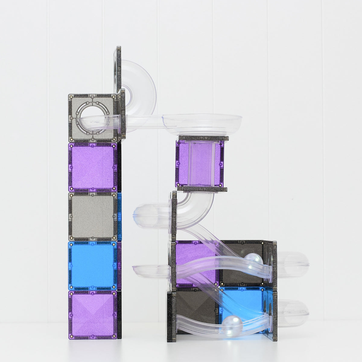 Glittery purple, blue, and black magnetic tile ball run structure with clear tracks and silver balls.