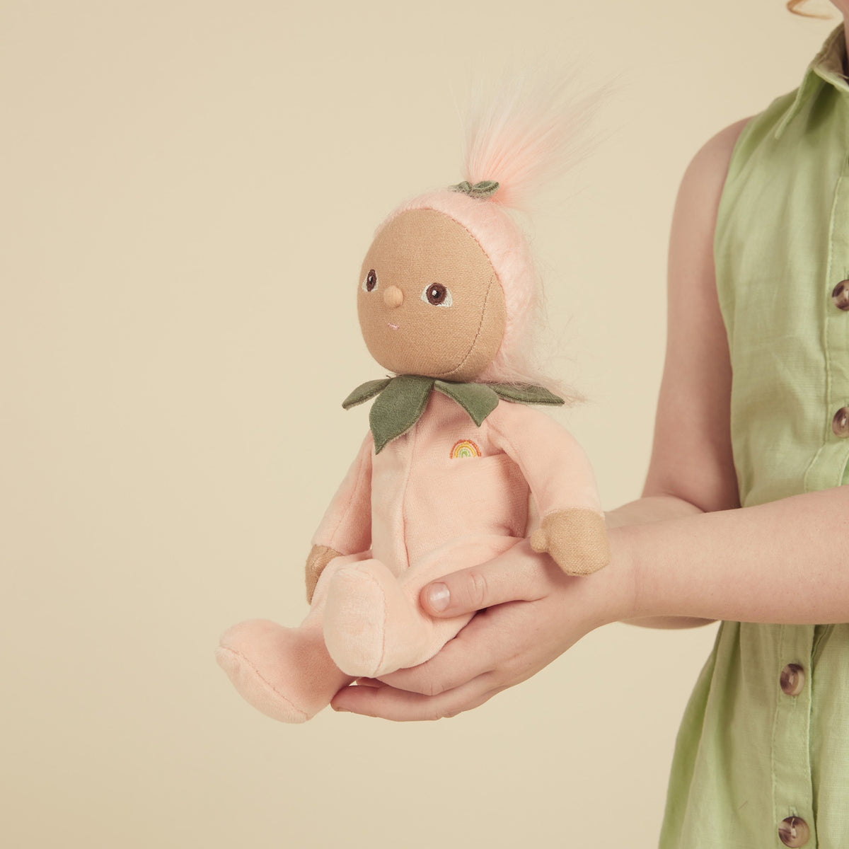Child holding a Dinky Dinkums Fruity Cuties Peggy Peach plush doll.