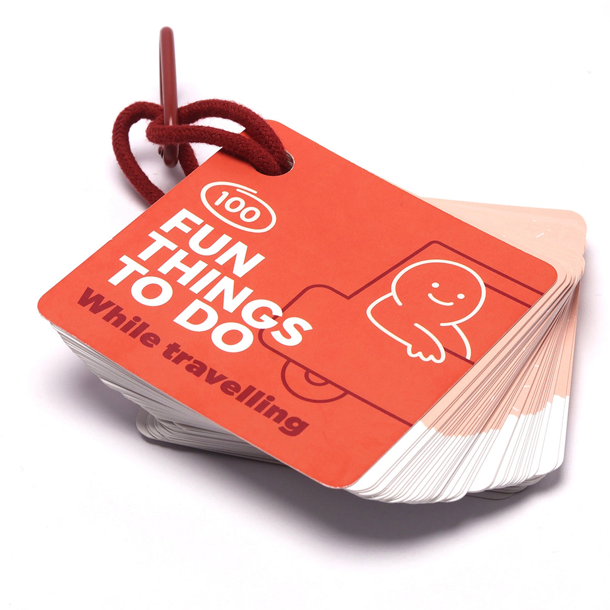Red "100 Fun Things to Do While Travelling" activity card deck attached to a ring clip.