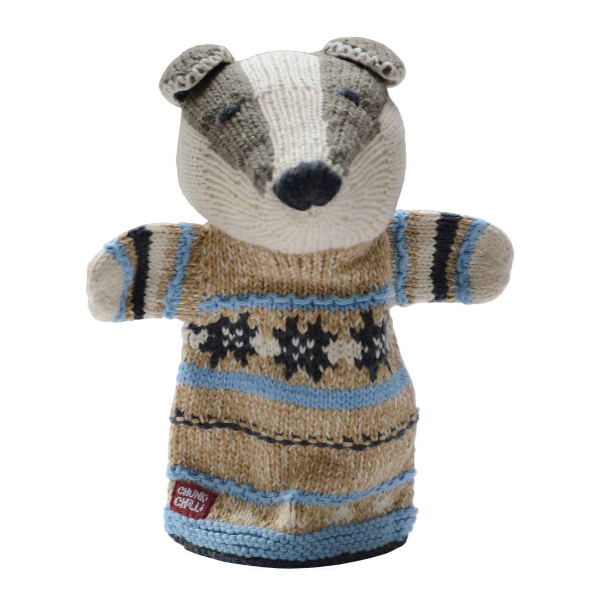 A knitted badger puppet wearing a cozy, patterned sweater in beige, blue, and black. It has a friendly expression and is set against a white background.