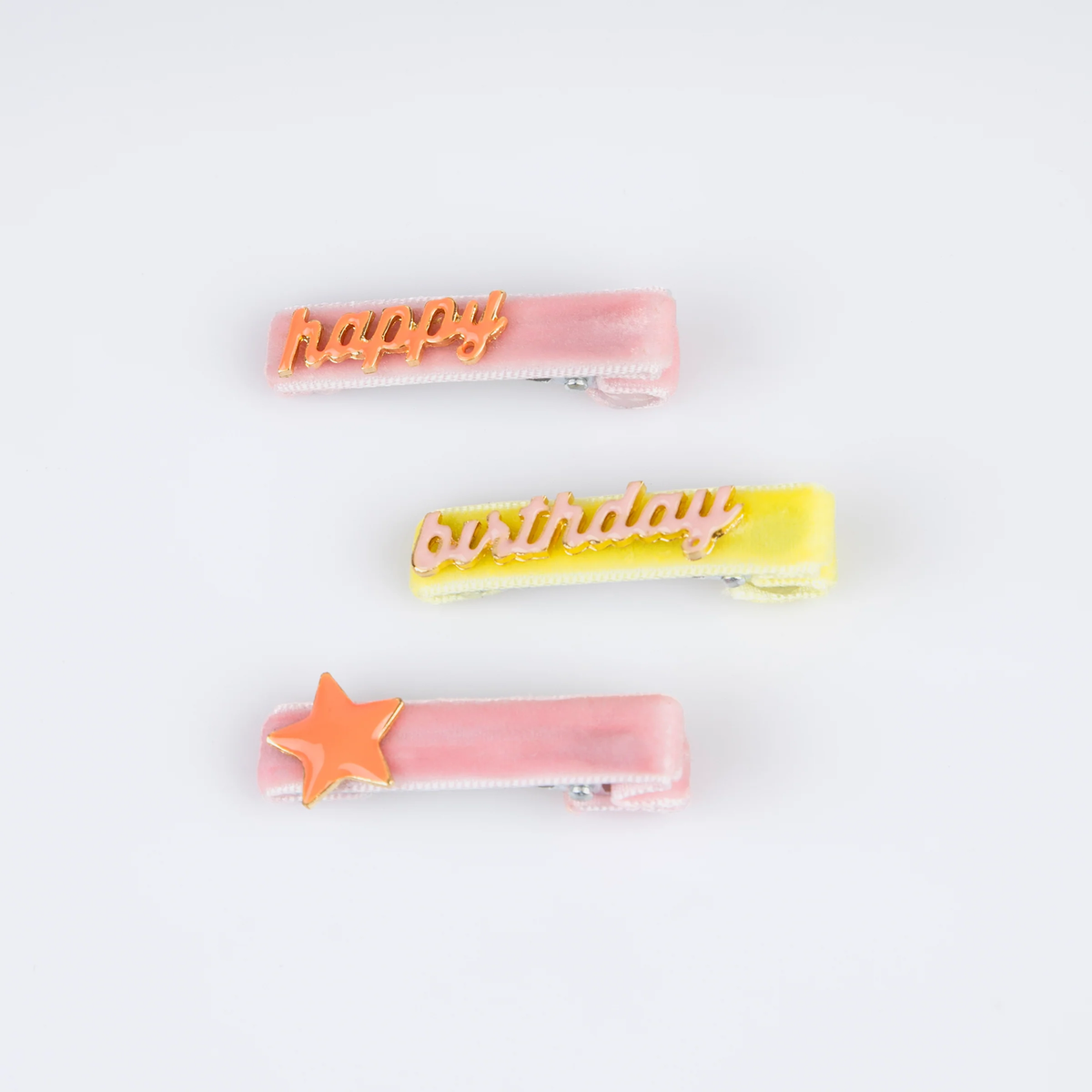 Three colorful velvet hair clips featuring text and a star charm.