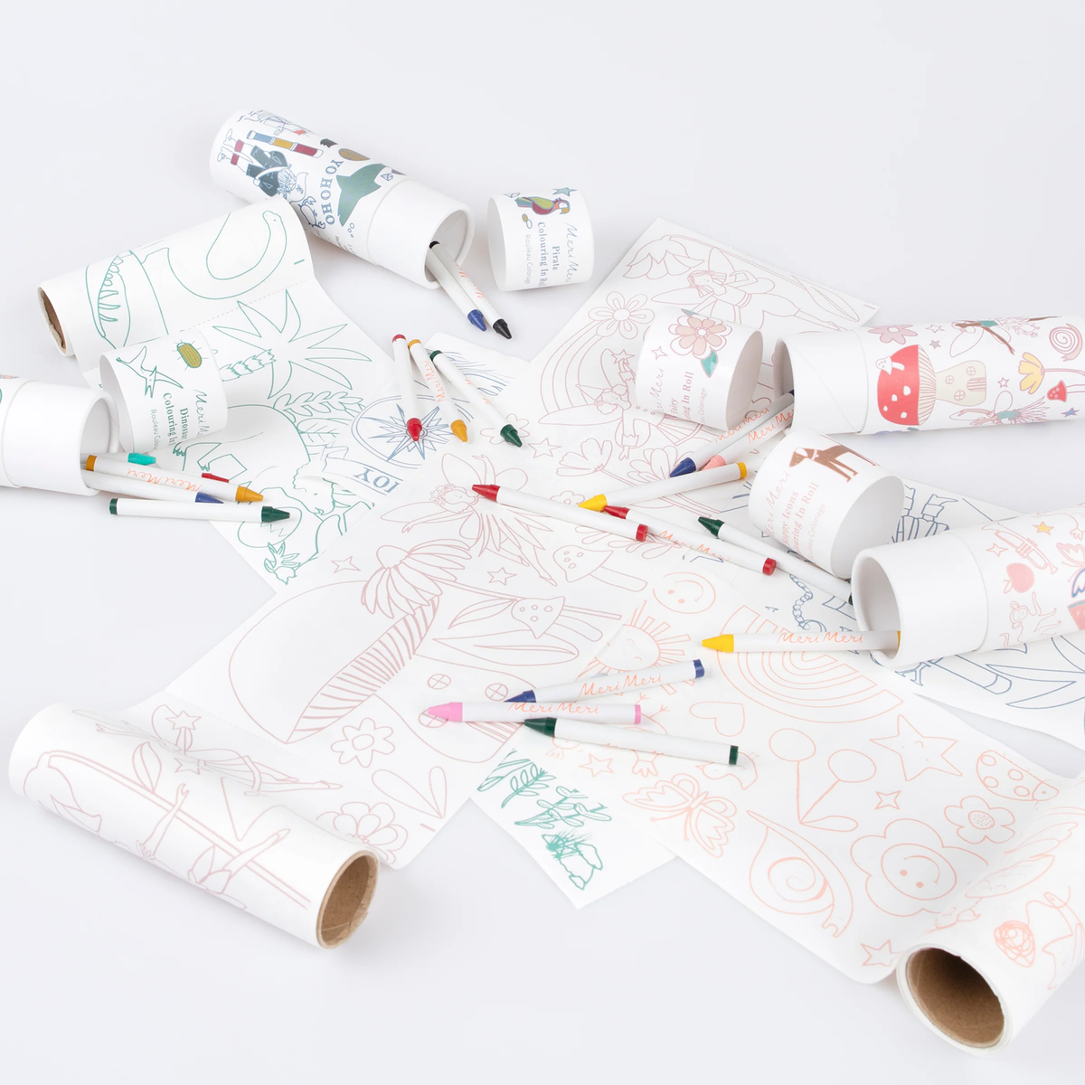 Unrolled coloring paper rolls scattered with crayons and packaging tubes on a plain white surface.