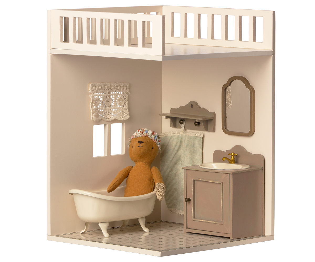A minimalist dollhouse bathroom with two small windows and curtains, featuring a decorated tiled floor.