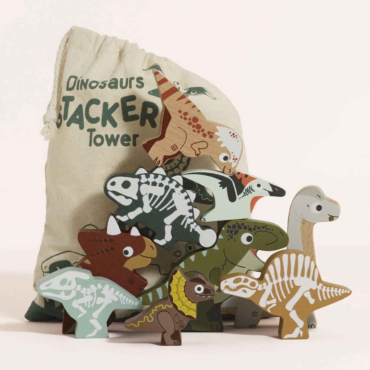 Wooden dinosaur figures stacked in front of a printed cotton storage bag.