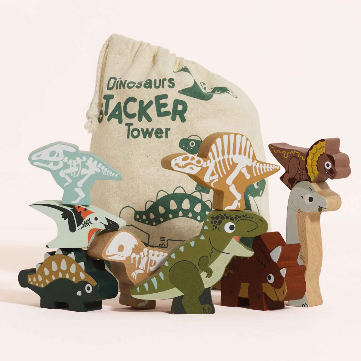 Wooden dinosaur toy figures stacked in groups in front of a printed drawstring bag.