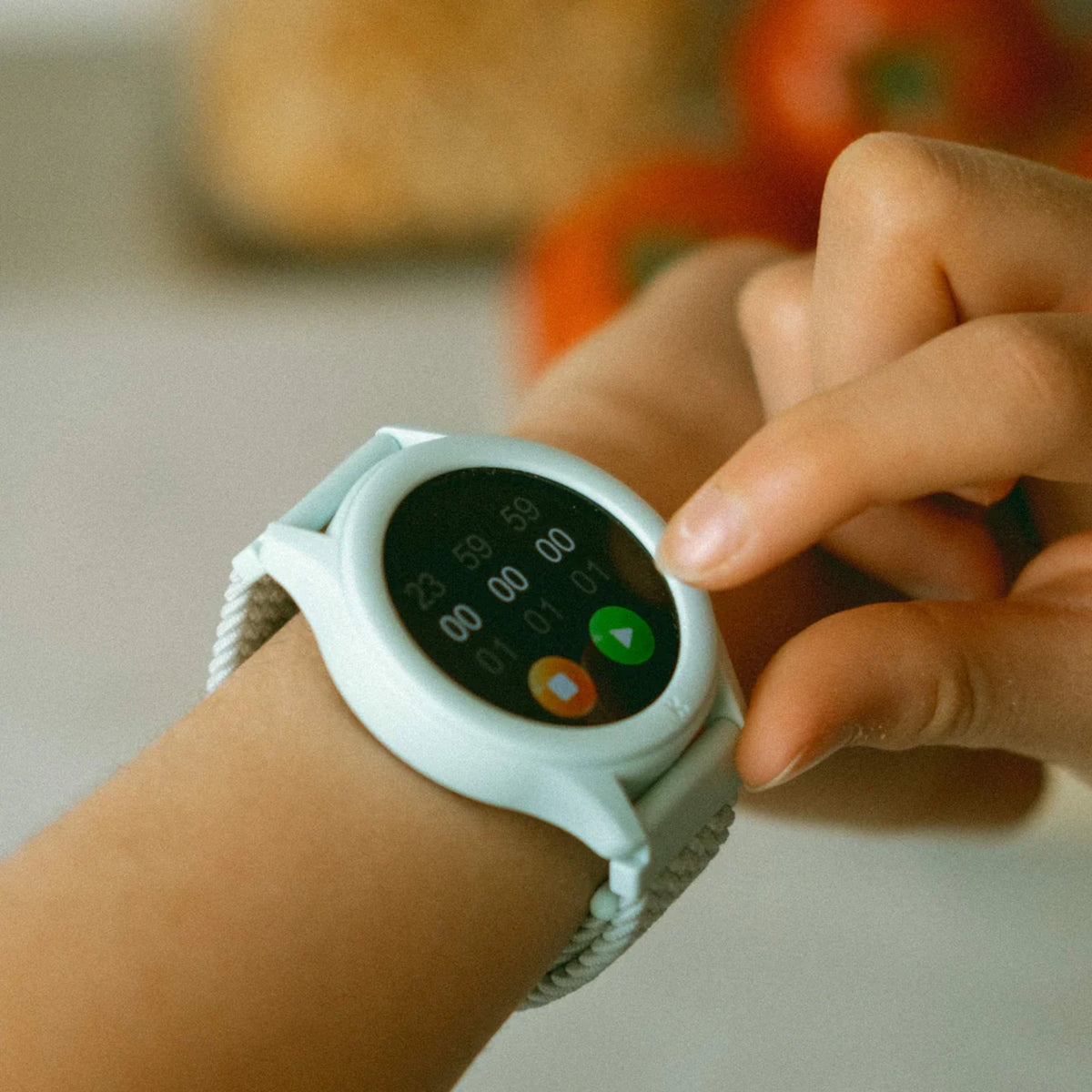 A close-up of a hand touching a light blue smartwatch screen displaying a timer.