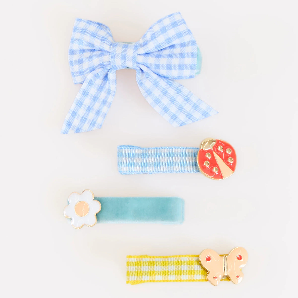 Four blue and yellow patterned hair clips featuring a bow, a ladybug, a flower, and a butterfly.