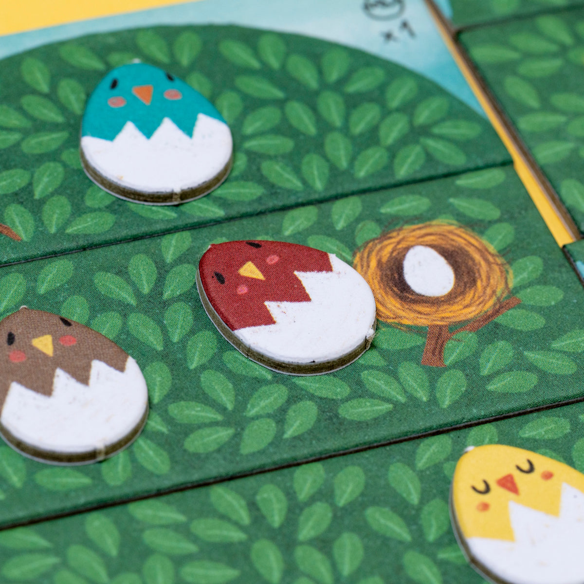 Colorful Londji Piu Piu board game tiles featuring illustrated birds in cracked eggshells on a green leaf background.