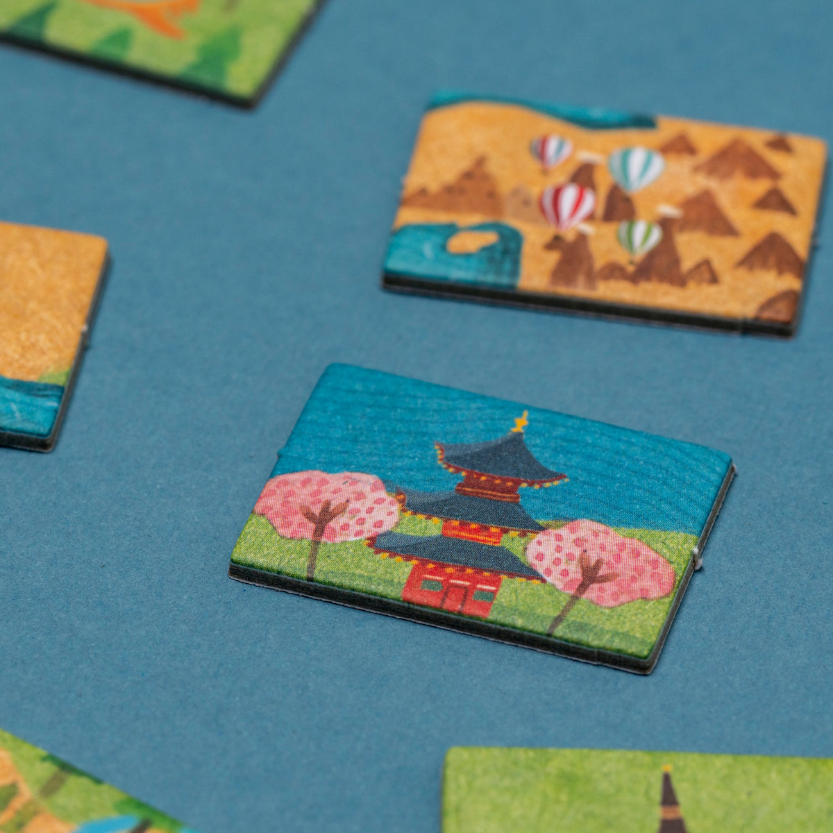 Colorful Londji Wonderful World game tiles featuring a Japanese pagoda and cherry blossoms on a blue background.