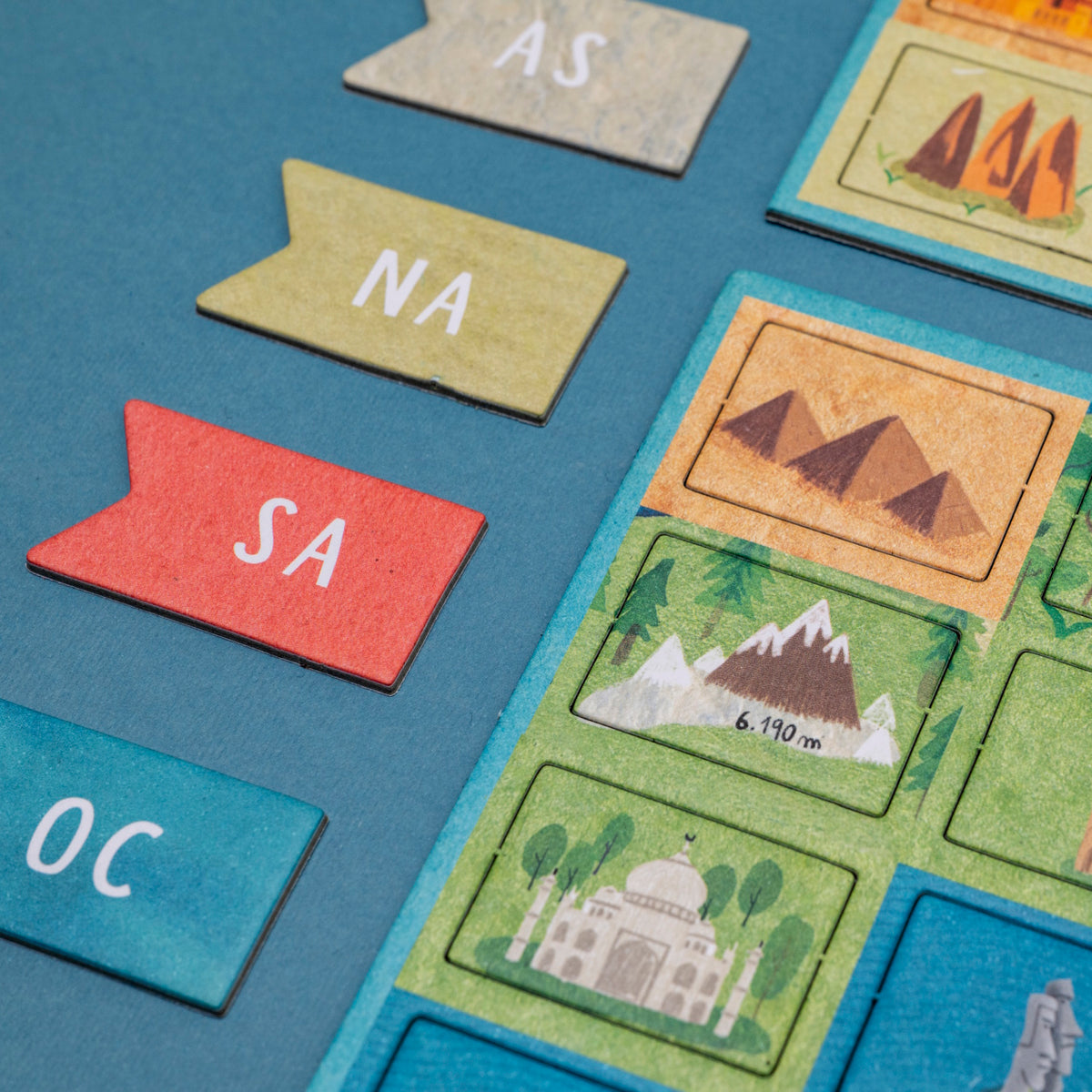 Londji Wonderful World board game pieces featuring continent initials and illustrated world landmark tiles.