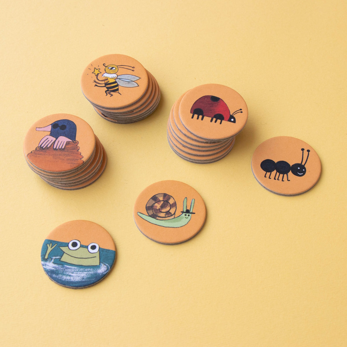 Stacks of Londji Bear's Forest Puzzle round cardboard tokens featuring illustrated forest animals and insects.