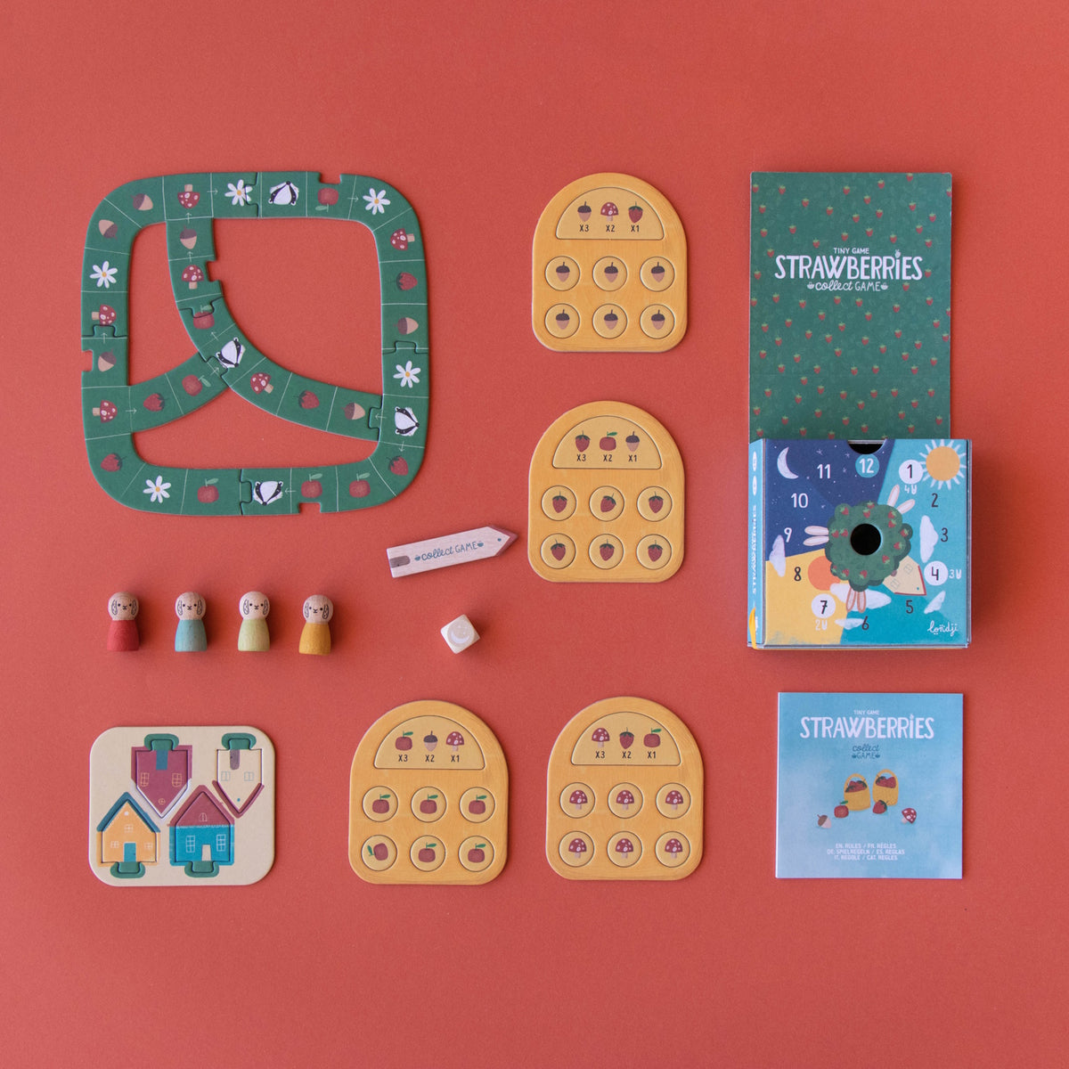 Londji Strawberries Tiny Game components with wooden tokens, cards, and game board on a red background.