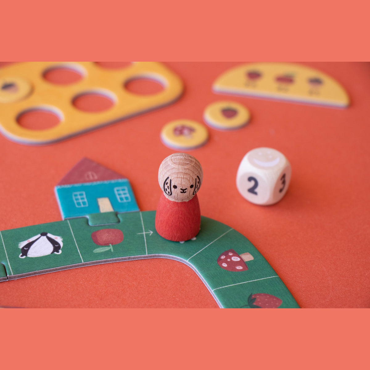 Londji Tiny Game Strawberries featuring wooden dog pawn, dice, and colorful forest-themed game board pieces.