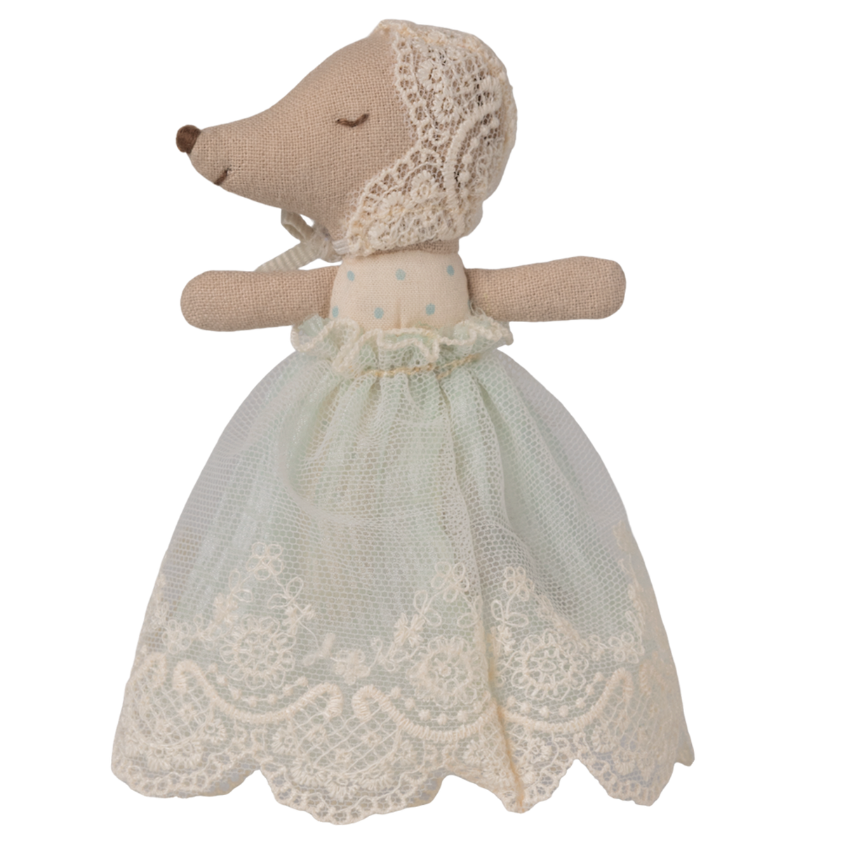 A soft toy with a mouse-like snout and closed eyes, wearing a delicate lace bonnet and a pale blue, lace-trimmed dress, set against a white background.