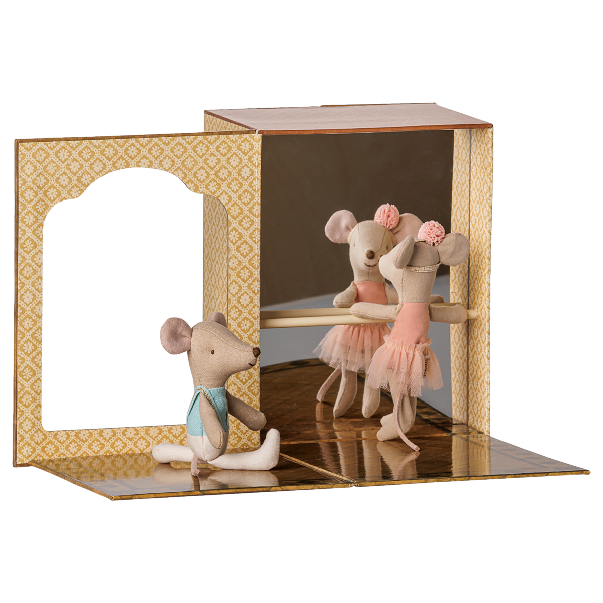 Two fabric toy mice practice ballet inside a miniature cardboard dance studio with a mirror and barre.