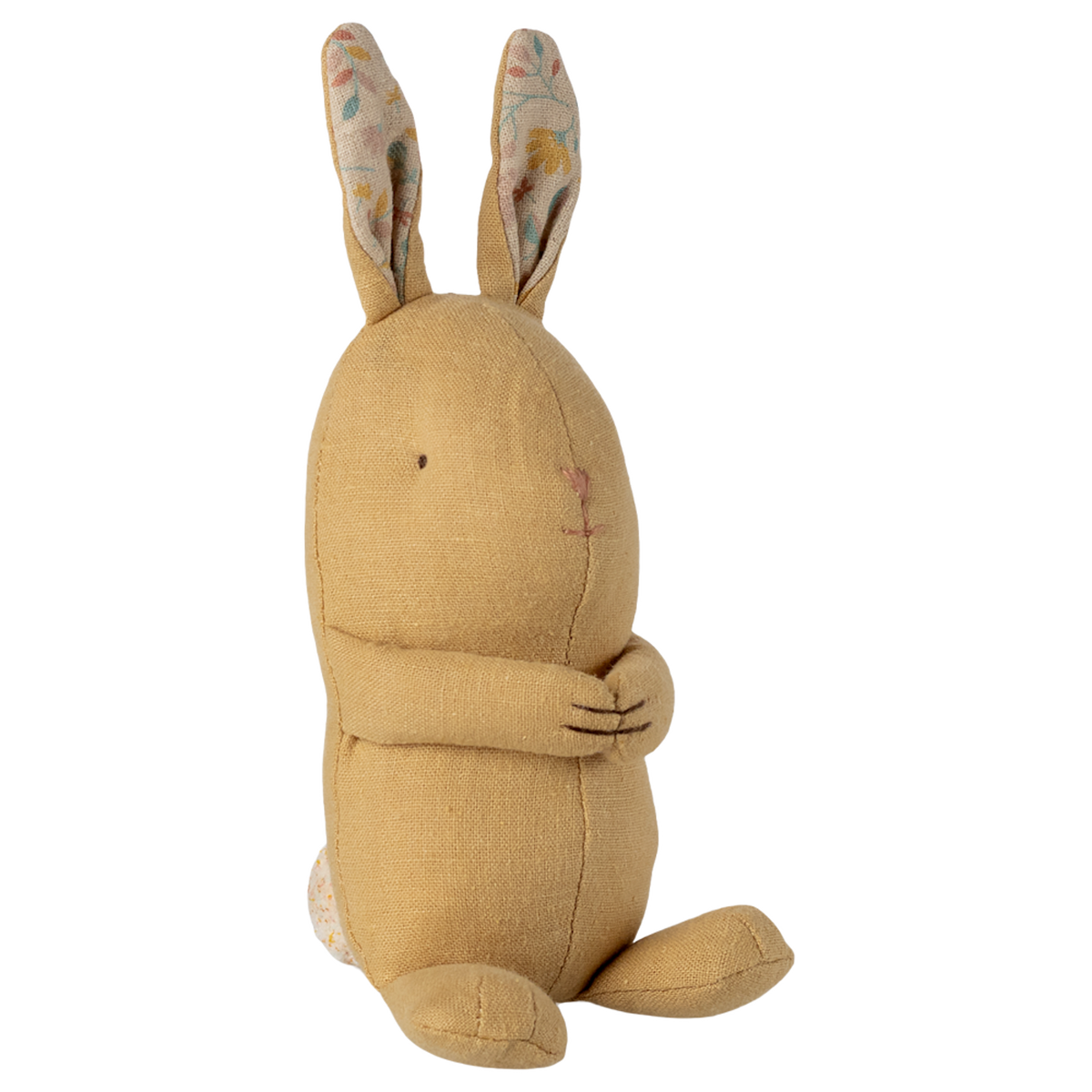 A soft, yellow fabric rabbit toy with long ears featuring a floral pattern sits against a white background. It looks cute and cuddly with stitched features.