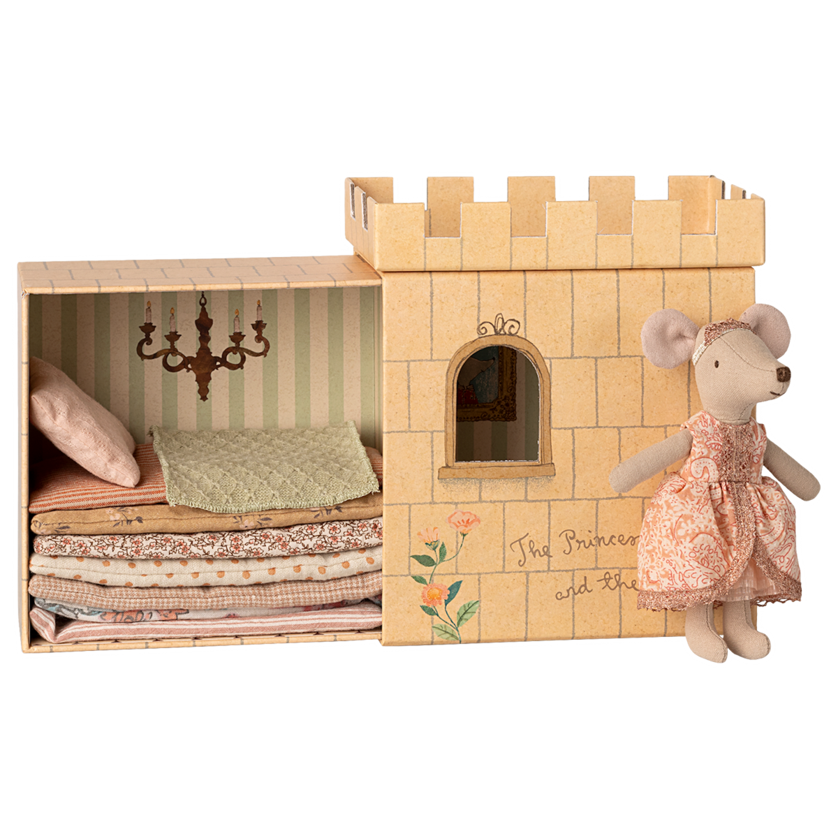 Toy set depicting "The Princess and the Pea" with a plush mouse in a patterned dress beside a castle box. Inside, layered mattresses are under a chandelier.