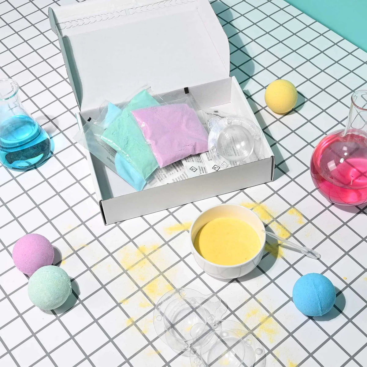 Open Nailmatic Bath Bomb Maker kit with colored powders, molds, mixing bowl, and finished bath bombs.