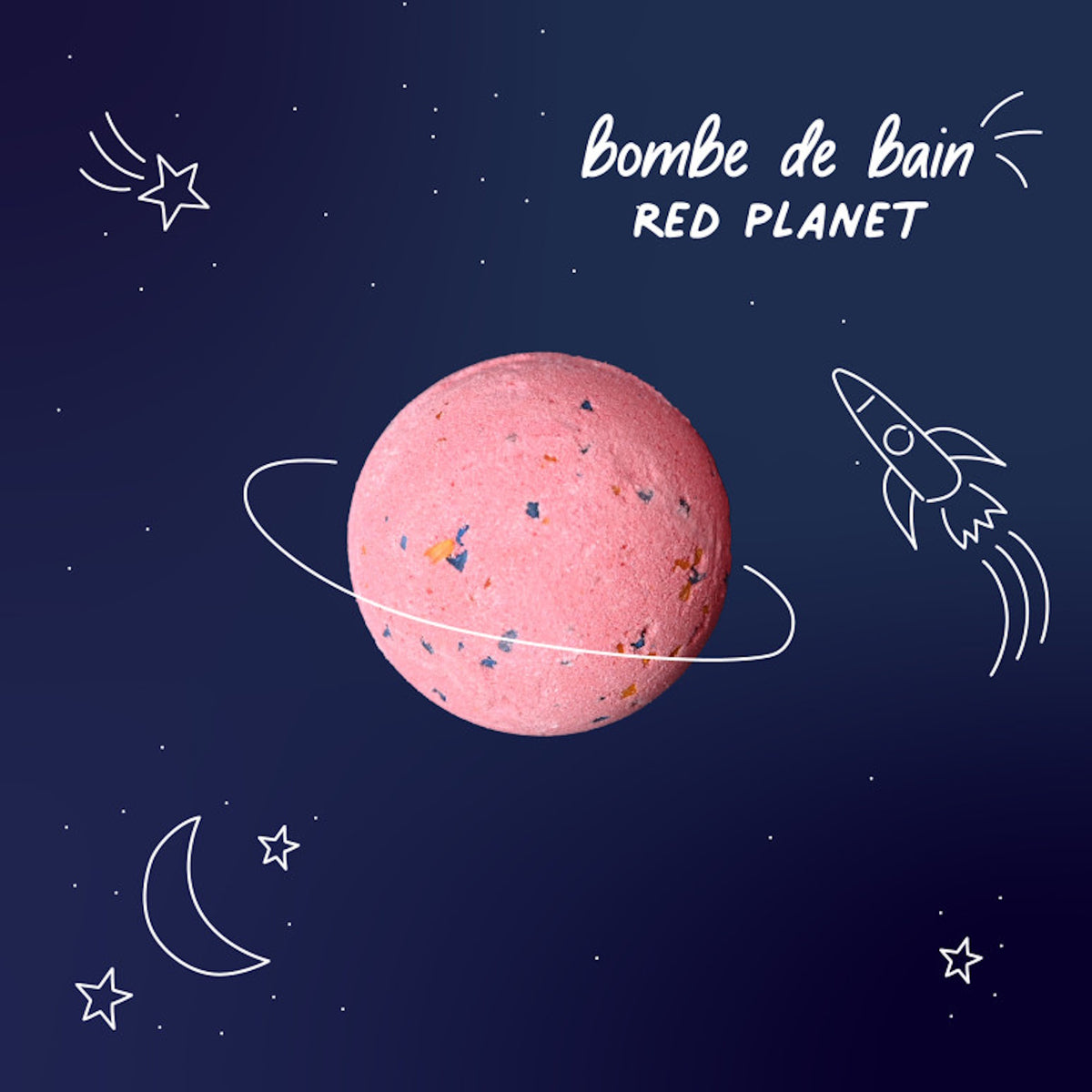Pink bath bomb resembling a planet with doodles of a crescent moon, stars, and a rocket on a dark blue background. Text reads "bombe de bain, Red Planet."