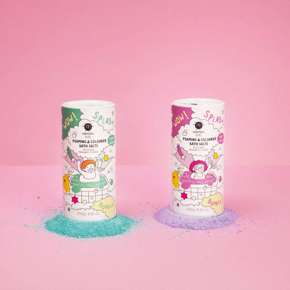 Two colorful, cylindrical containers of foaming bath salts stand on a pink background. Left is turquoise, right is purple, with spilled powder beneath.