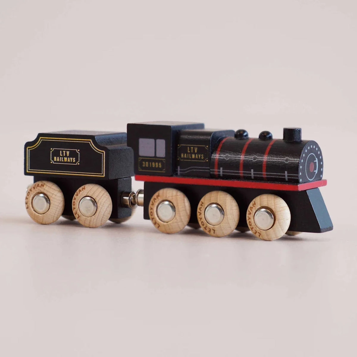 Black wooden toy steam train with LTV Railways branding and natural wood wheels viewed from the front side.