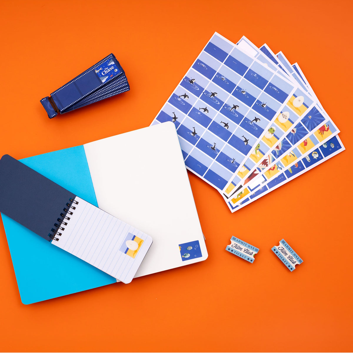 Ocean-themed flip book animation kit with stickers, notebooks, film strips, and tickets on an orange background.