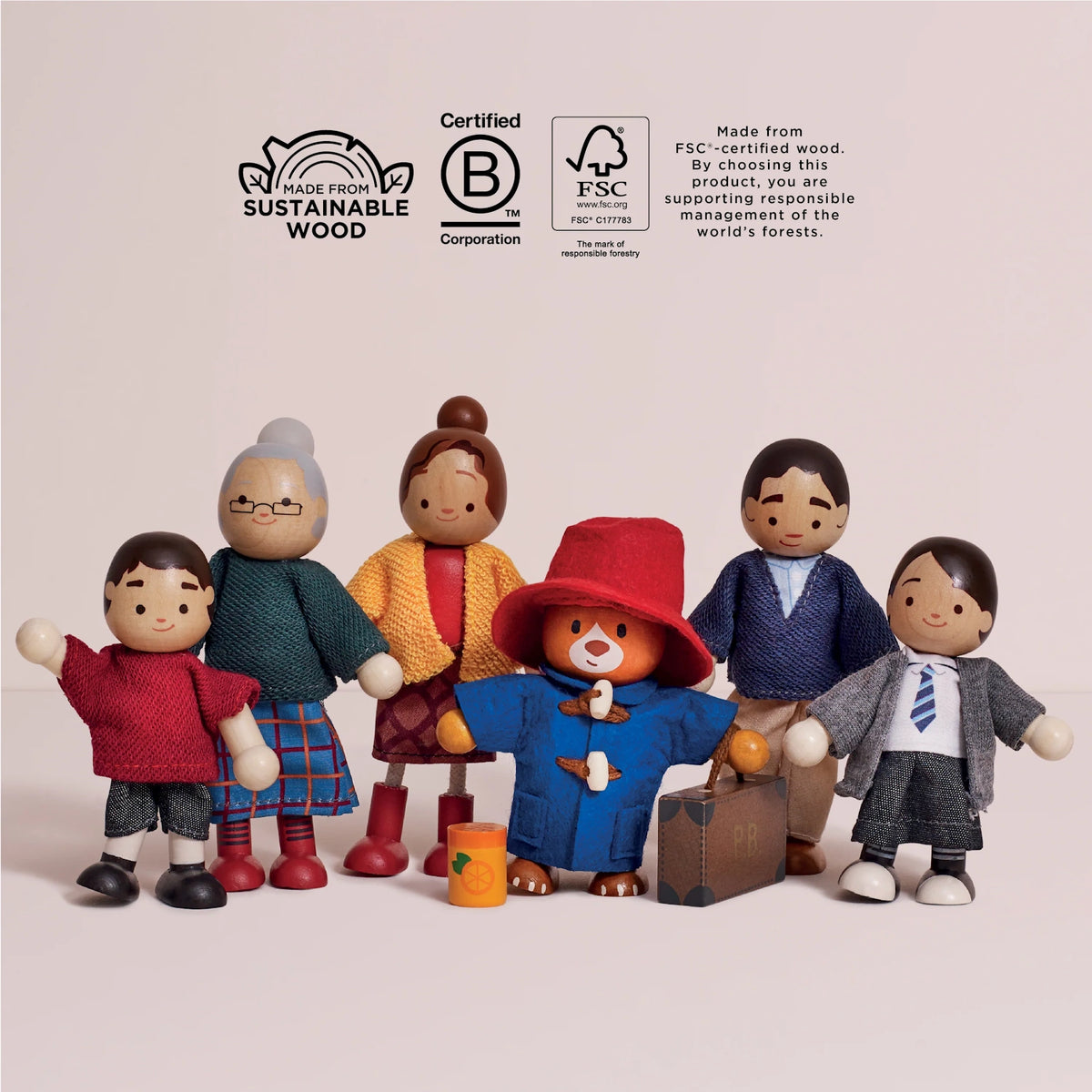 Wooden Paddington Bear and family dolls standing together below sustainable wood and FSC certification logos.