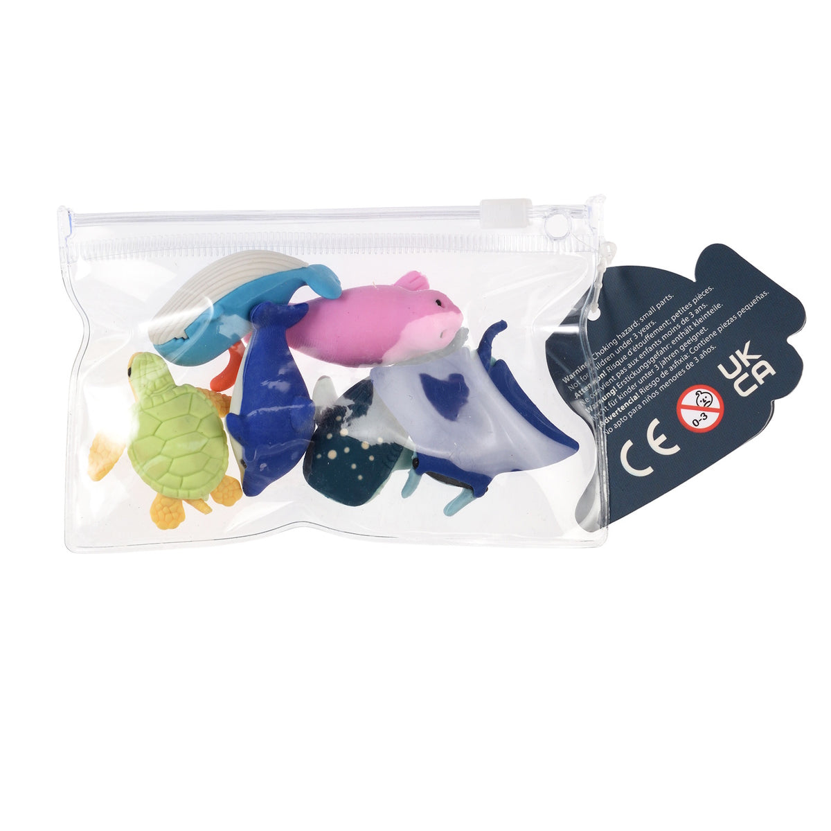 A clear plastic bag contains colorful toy sea animals, a green turtle, blue whale, pink seal, and manta ray. A warning and CE mark is visible on a tag.