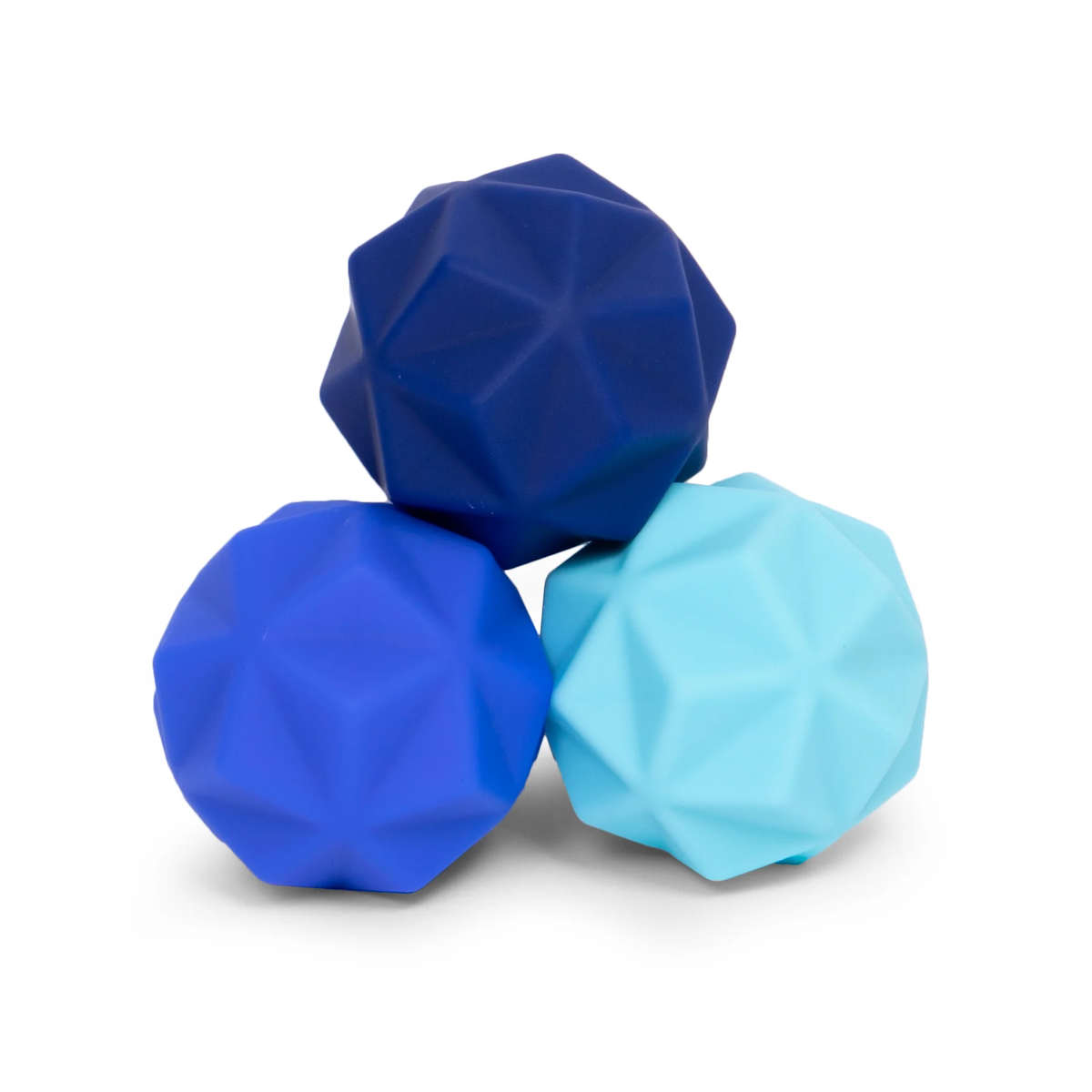 Three textured balls sit together, each with a faceted surface. They are colored navy blue, royal blue, and light blue, creating a calming visual effect.