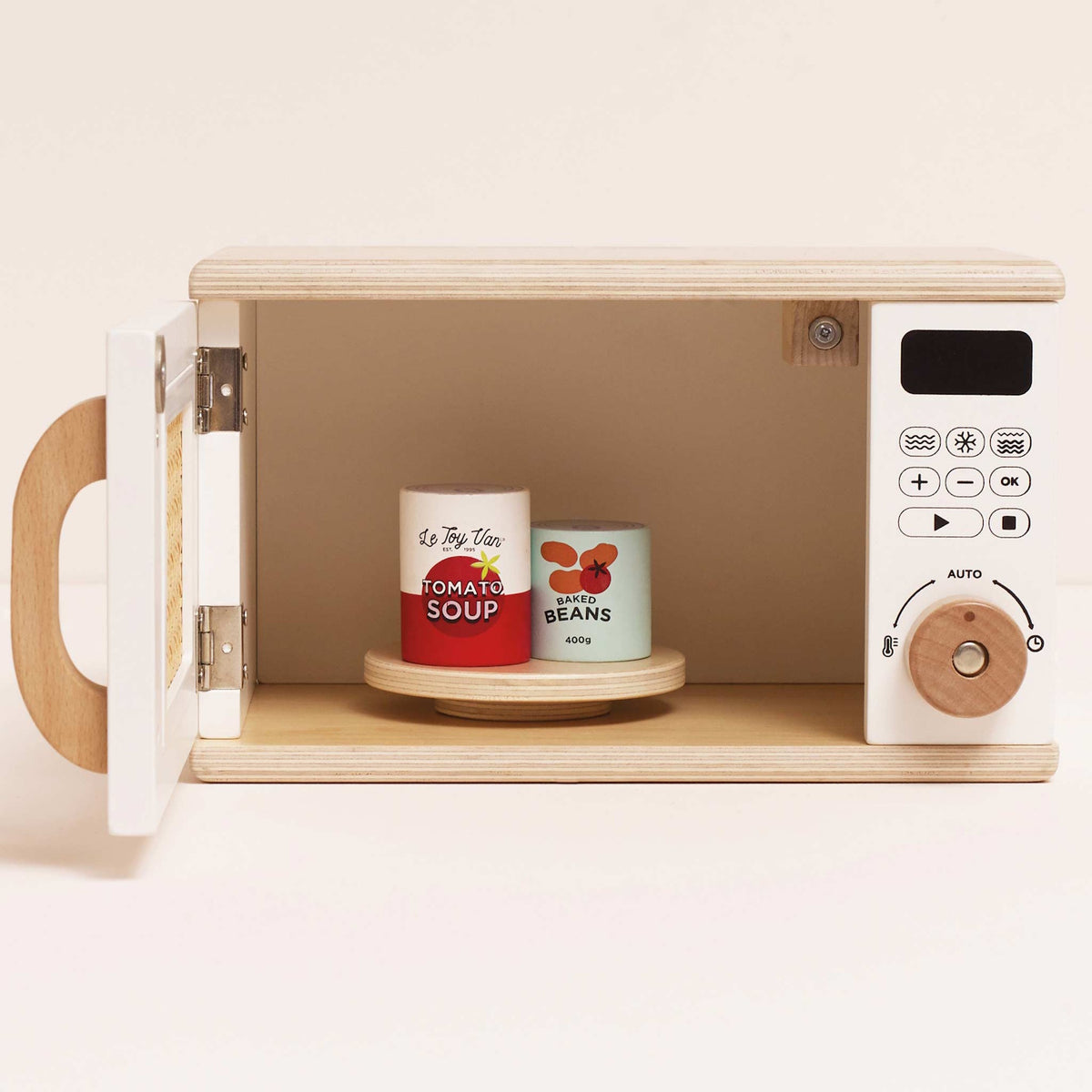 Open wooden toy microwave with toy tomato soup and baked beans cans inside.