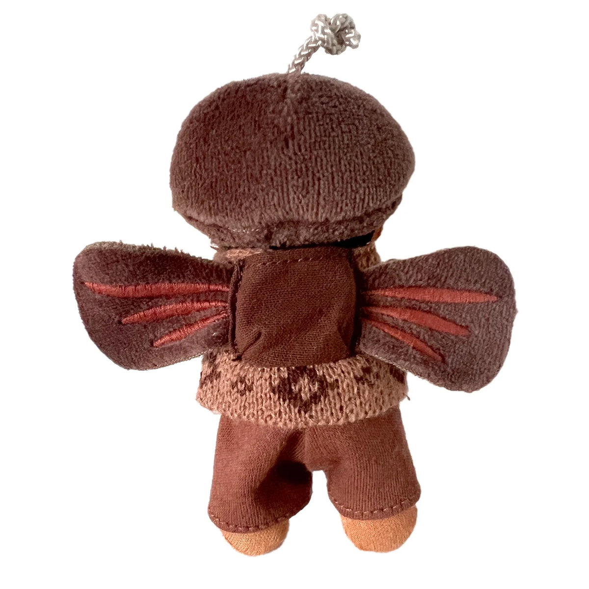 Back view of a small plush forest fairy doll with brown wings and a small backpack pouch on its sweater.