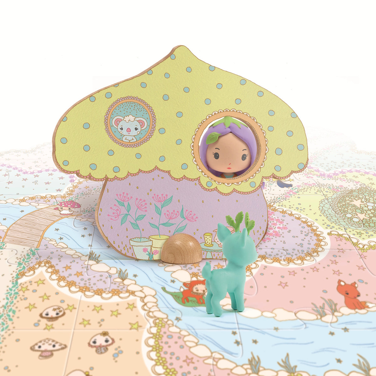 A colorful mushroom-shaped house with a doll peeking out, surrounded by a whimsical, illustrated landscape and a green toy deer.