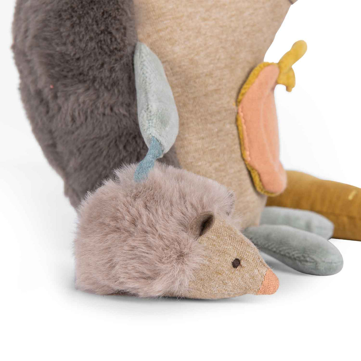 Close-up of a plush toy hedgehog with a smaller hedgehog baby attached to its side against a white background.
