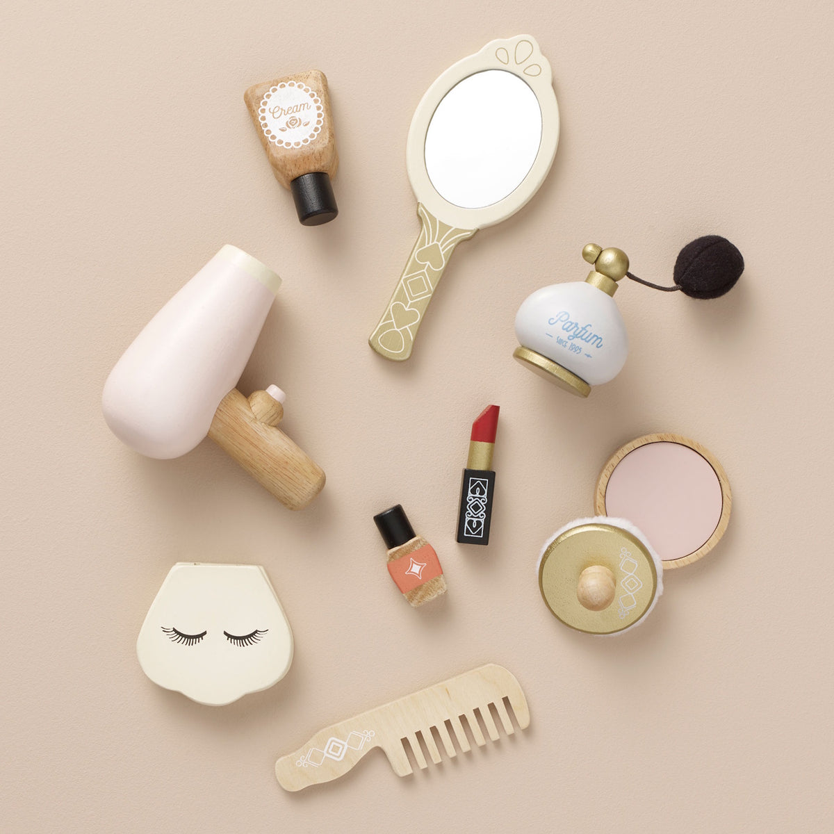 Flat lay of wooden toy makeup and hair accessories including mirror, hair dryer, comb, and perfume.