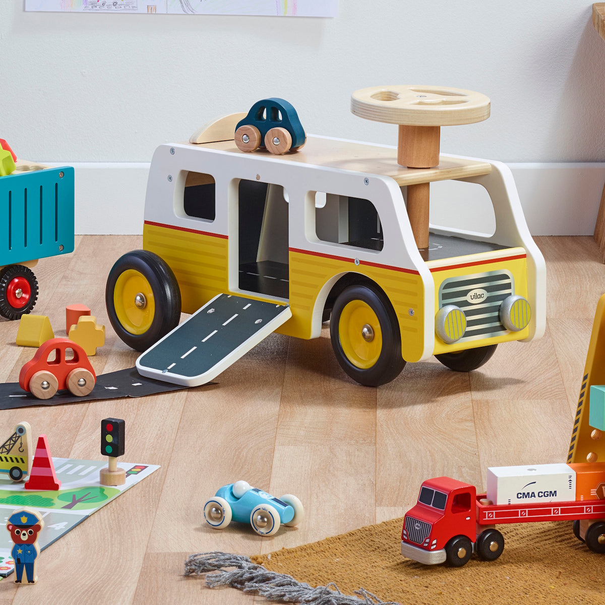 Vilac wooden toy garage bus with ramp, steering wheel, and small colorful wooden cars on a play mat.