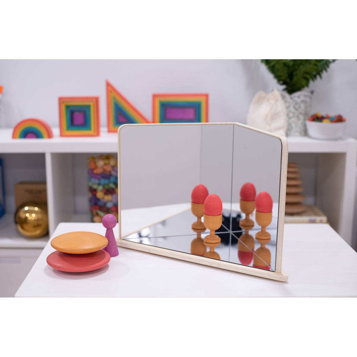 A wooden-framed mirror with four reflective panels arranged to create kaleidoscopic visual effects, ideal for sensory exploration and light play.
