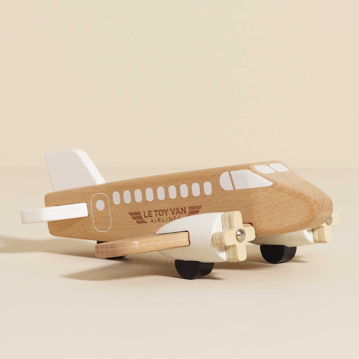 Natural wood and white passenger airplane toy with spinning propellers.