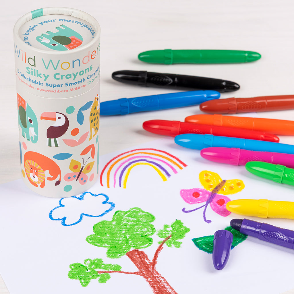 Colourful silky crayons beside a child's rainbow and butterfly drawing