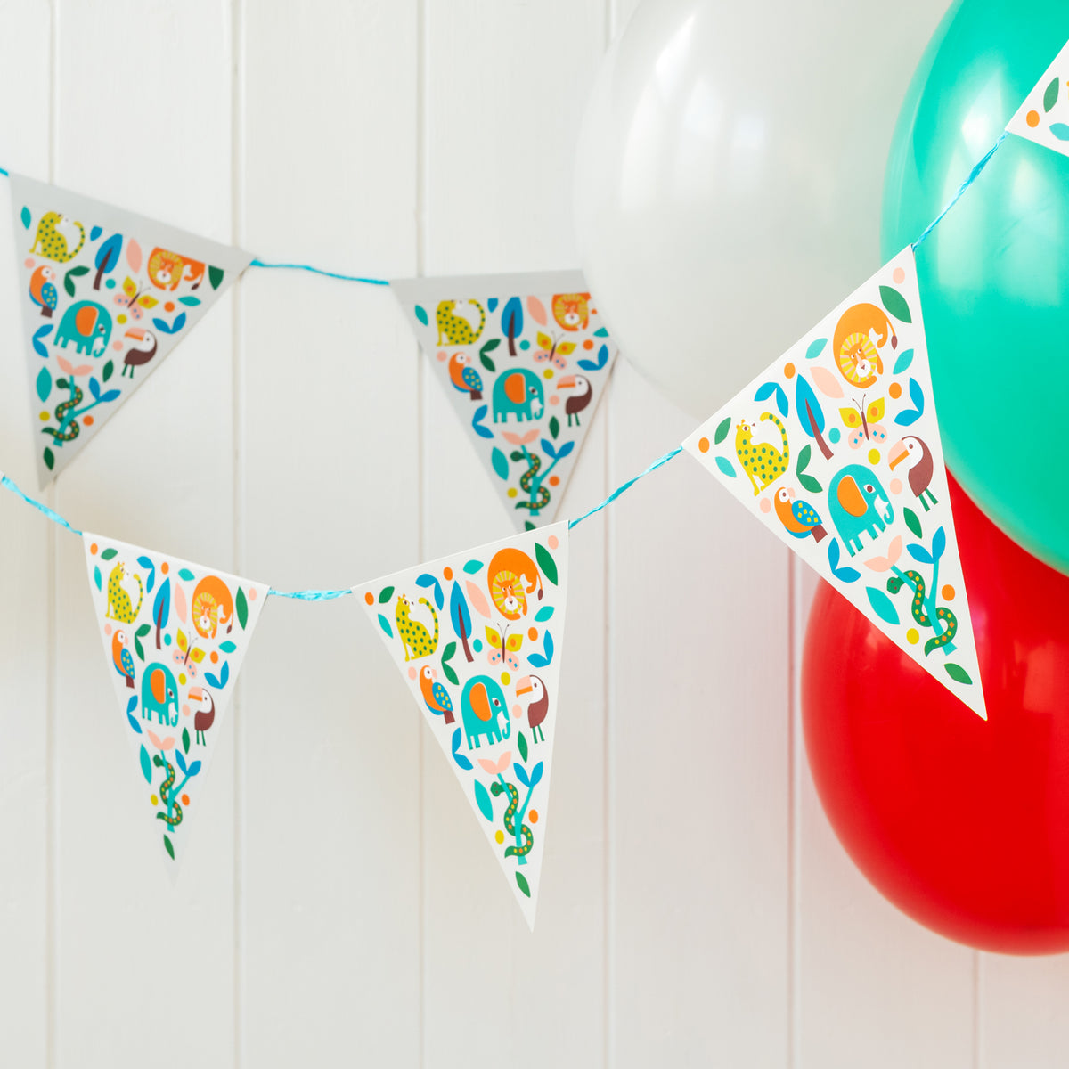 Jungle animal paper bunting hung above party balloons