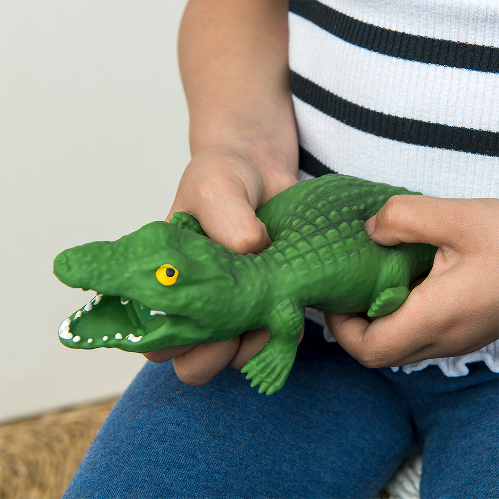 Child squeezing a stretchy sensory crocodile toy